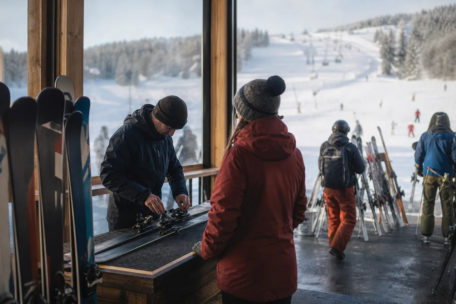Skidåkare provar och hämtar ut hyrda alpinskidor i en uthyrningsbutik vid backen