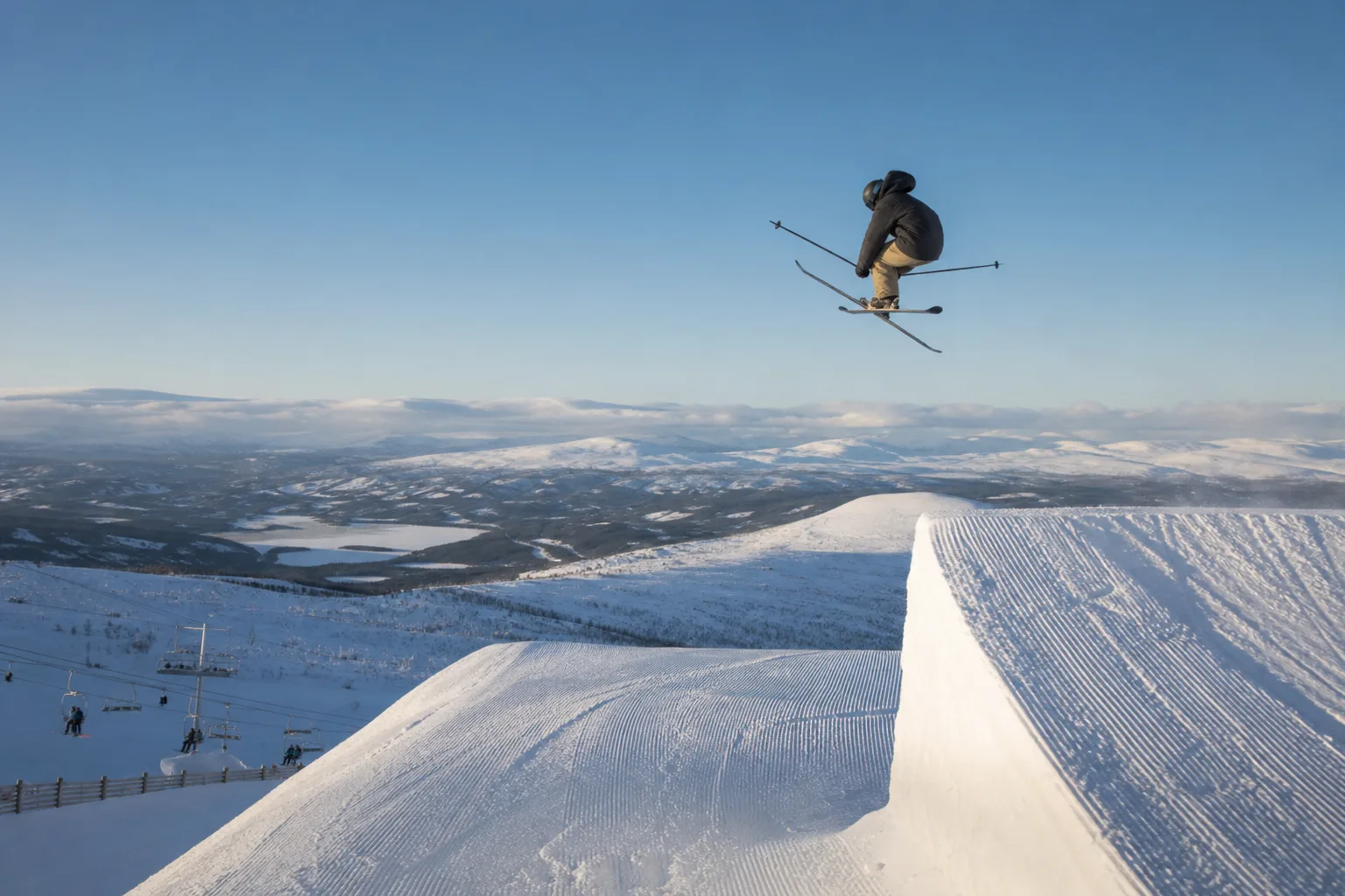 Skidåkare gör ett hopp i en snöpark på symmetriskt byggda parkskidor