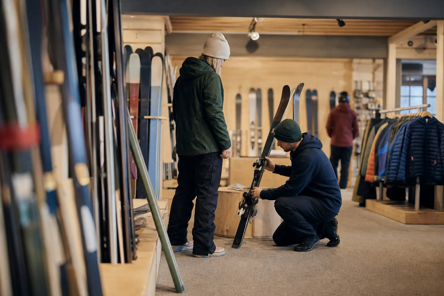 Skidåkare mäter och provsitter slalomskidor i en butik inför köp