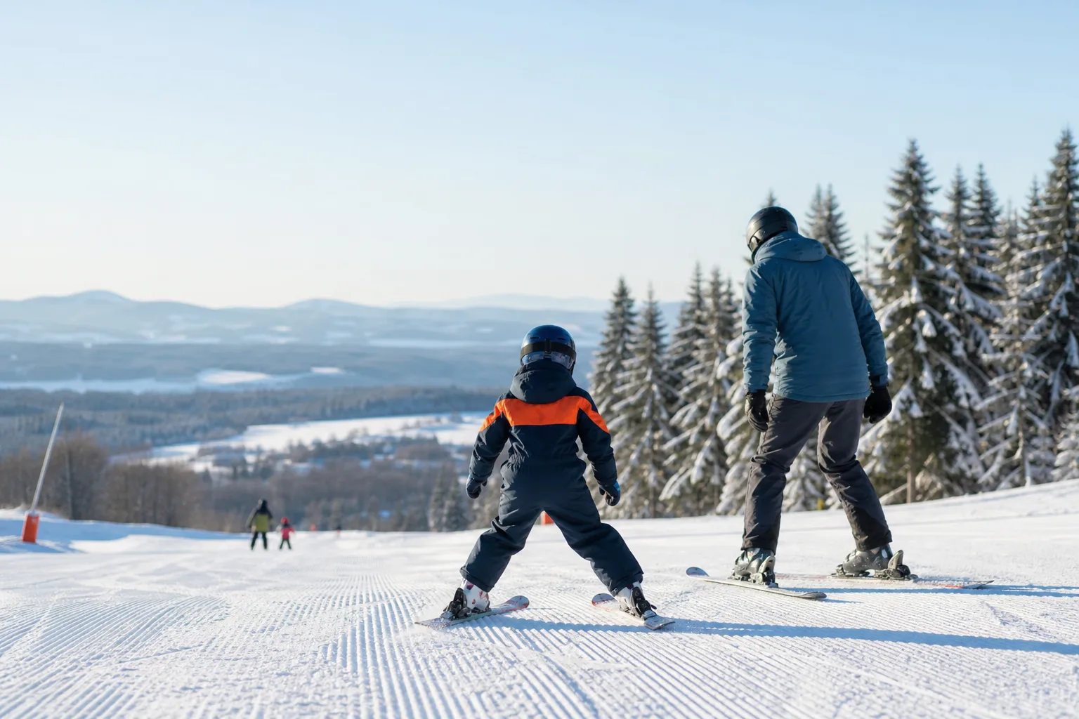 Barn provar slalomskidor tillsammans med en förälder inför säsongen