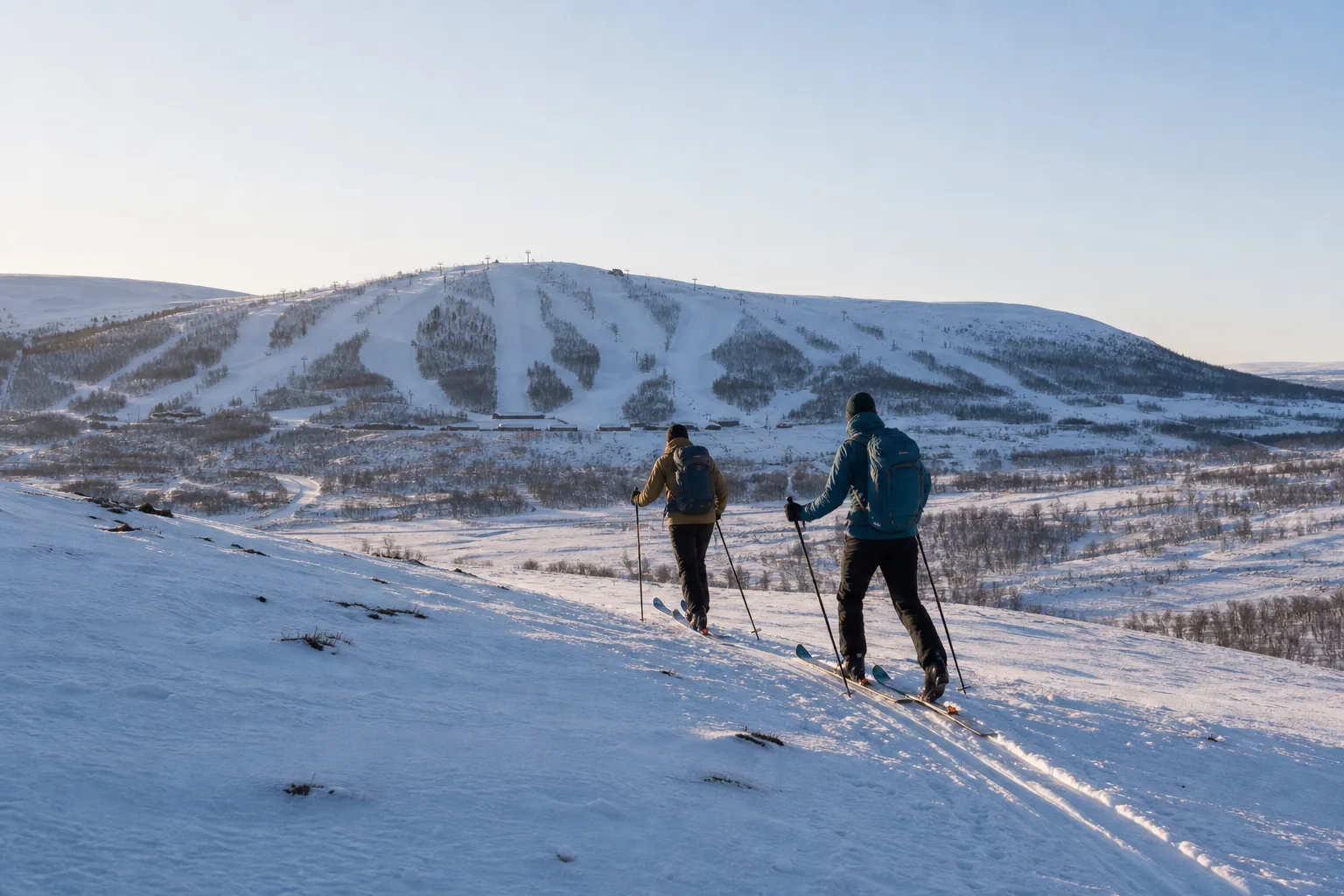 Skidåkare på topptur i fjällterräng ovanför Ramundbergets pistområde