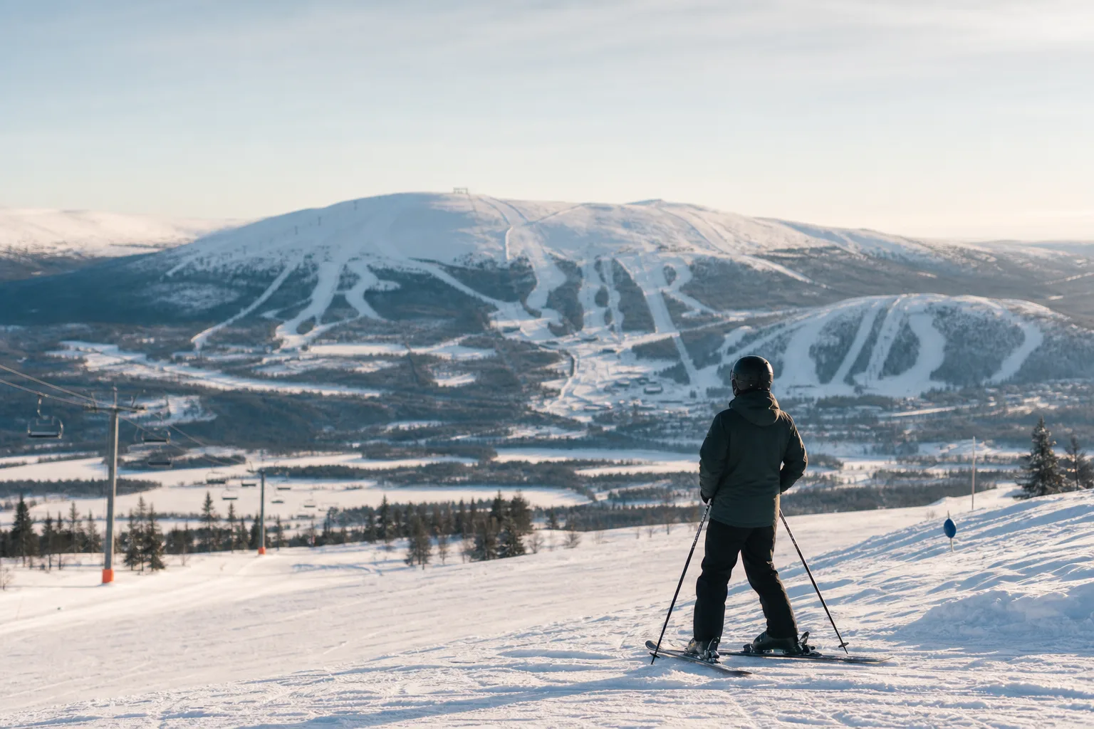 Skidåkare i Vemdalens fjällterräng med tre skidområden synliga i bakgrunden