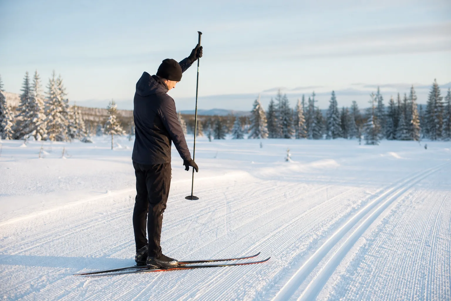 Skidåkare kontrollerar stavlängd genom att hålla staven upp och ned mot trugan